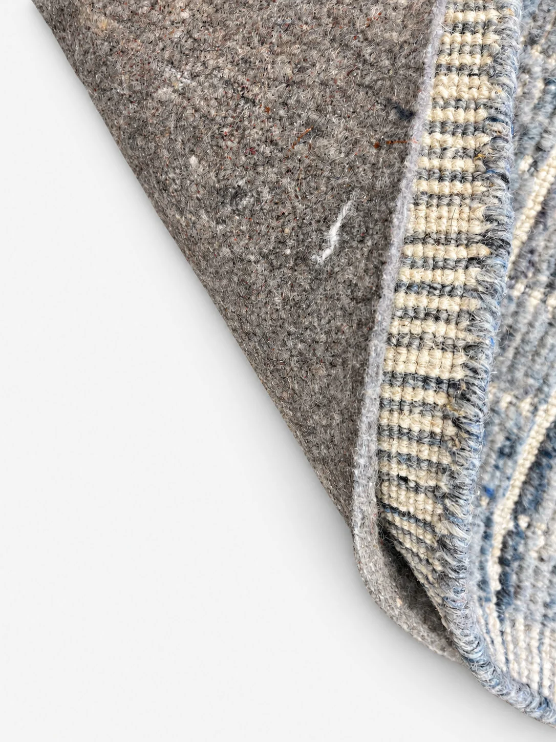 Everyday Support rug pad shown beneath a folded area rug