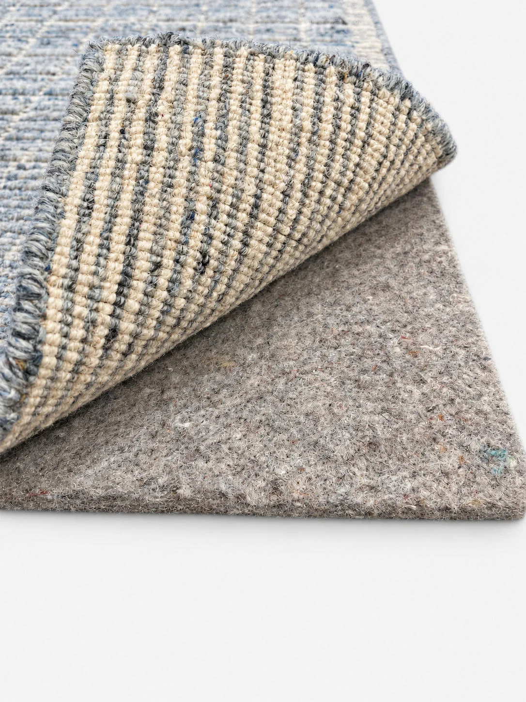 Everyday Support rug pad shown beneath a folded area rug