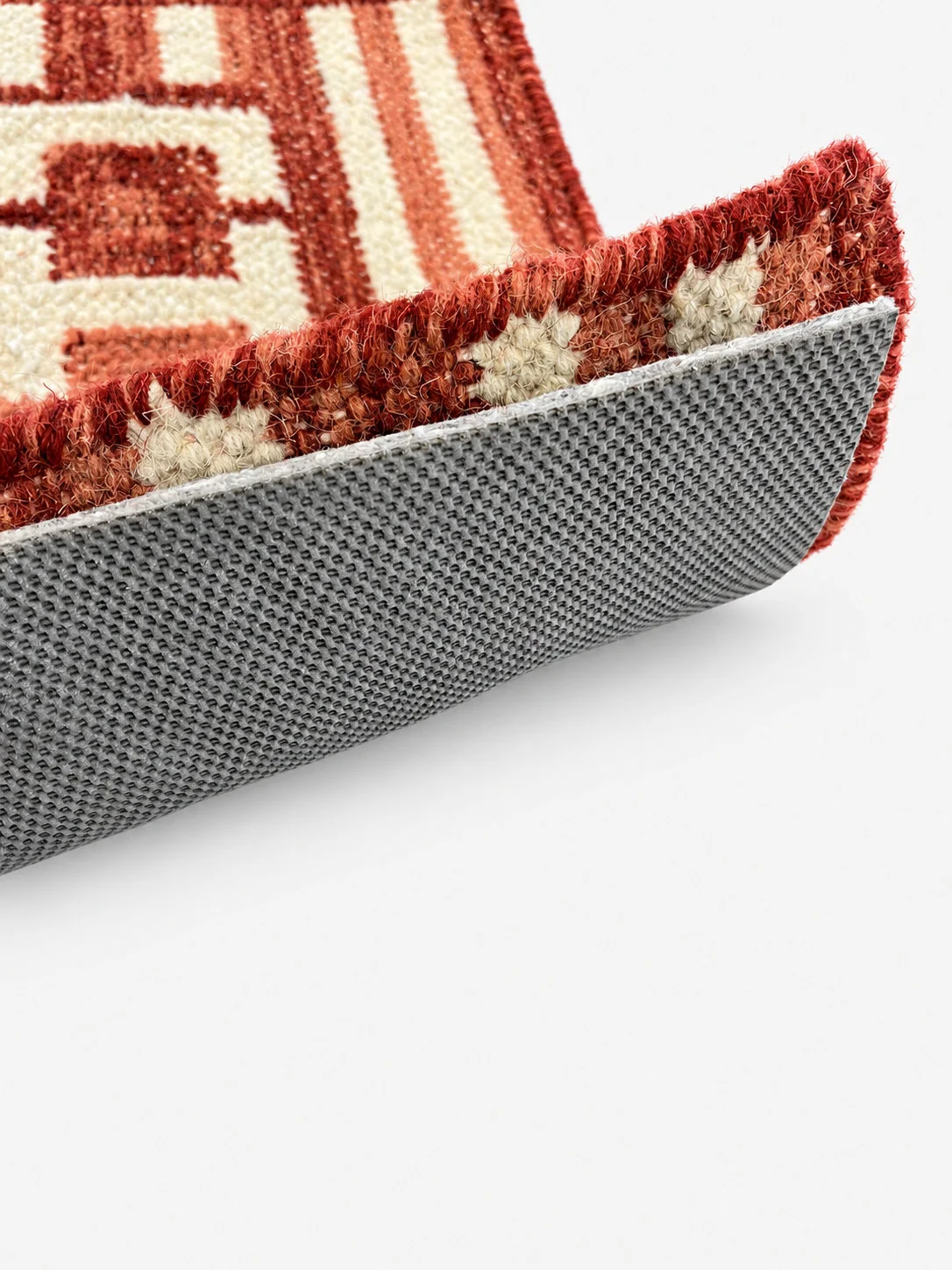 Sure Step rug pad shown beneath a folded area rug